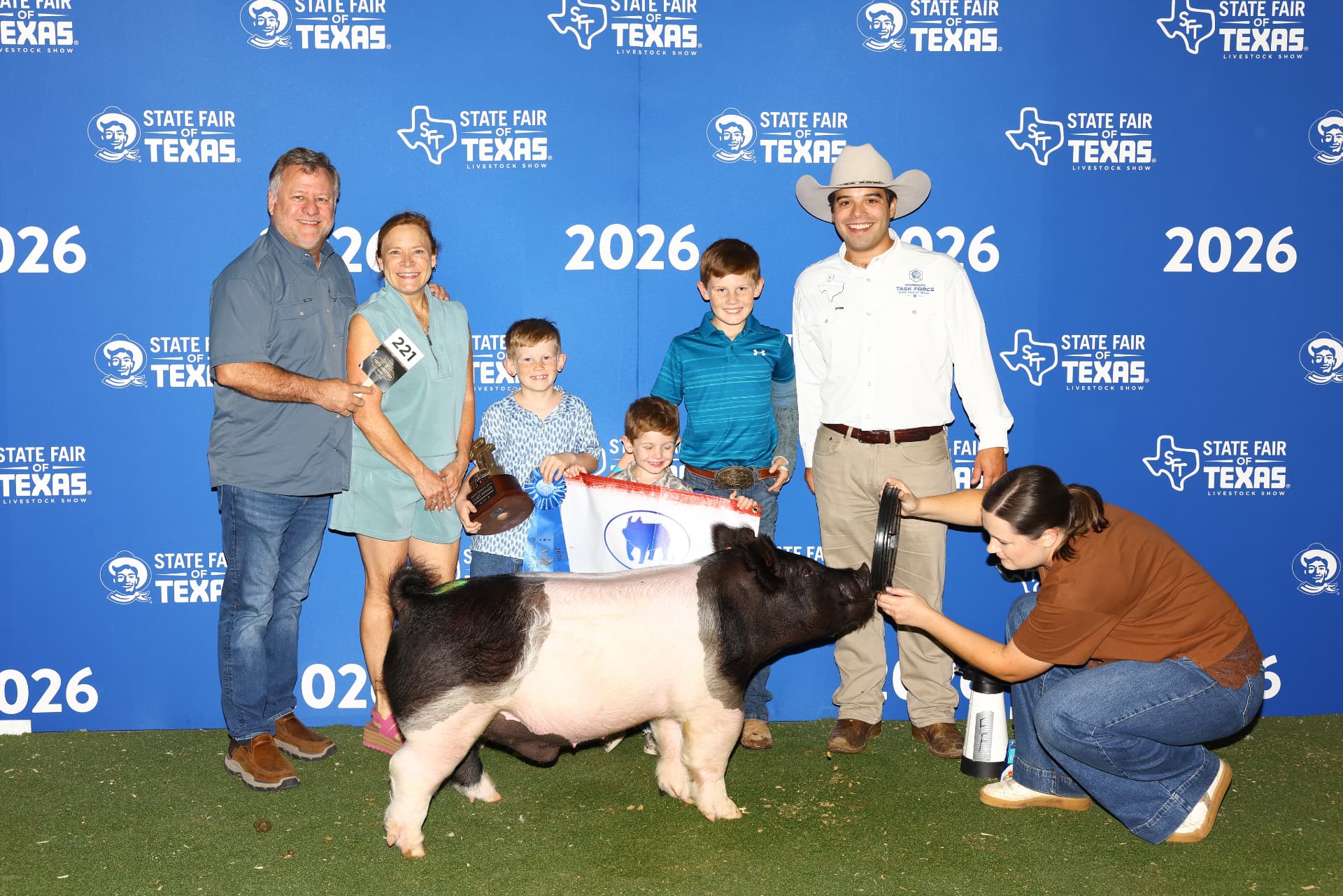Steven with a family and their champion pig at the State Fair of Texas livestock show